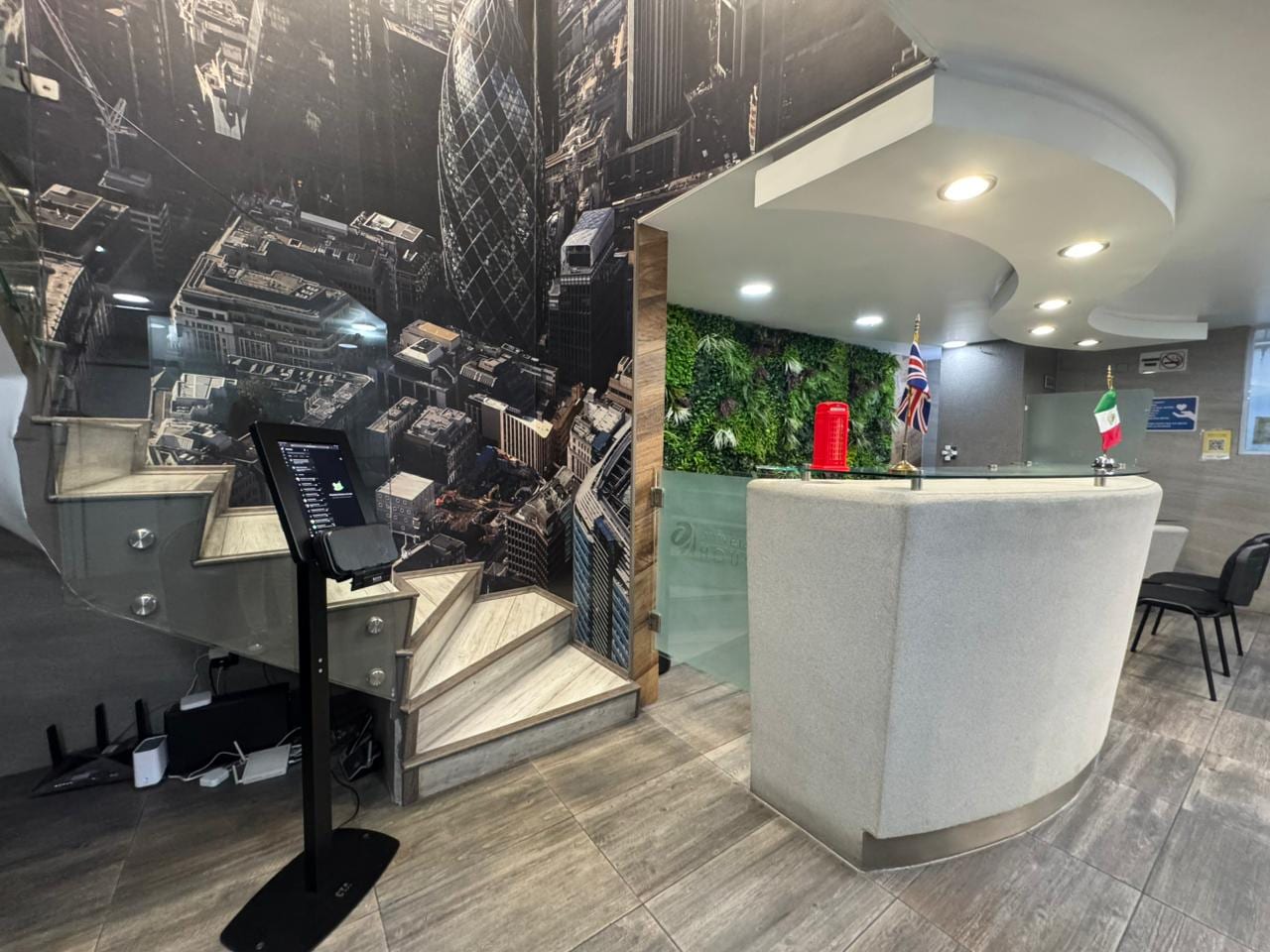 Recepción Universal House con mural panorámico de Londres y escalera